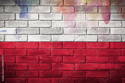 Flaga polski namalowana na ceglanym murze. The Polish flag painted on a brick wall. photo