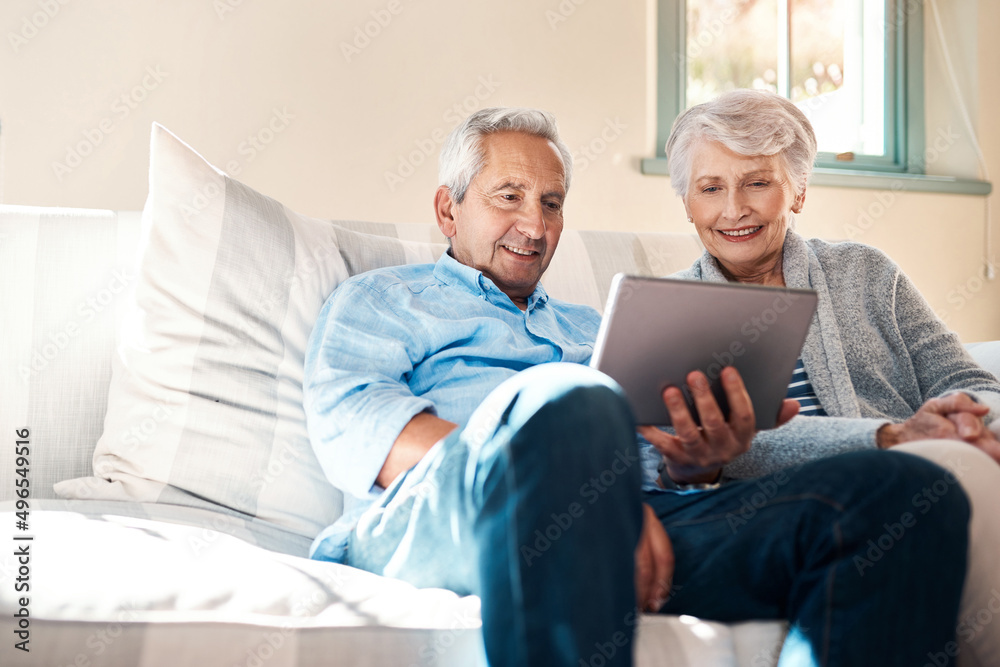 Embracing the era of smart technology. Shot of a senior couple using a digital tablet together in their living room at home. Embracing the era of smart technology. Shot of a senior couple using a digital tablet together in their living room at home.