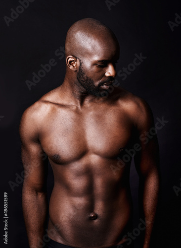 Thats one perfect specimen of a man. Cropped shot of a shirtless muscular man isolated on black.