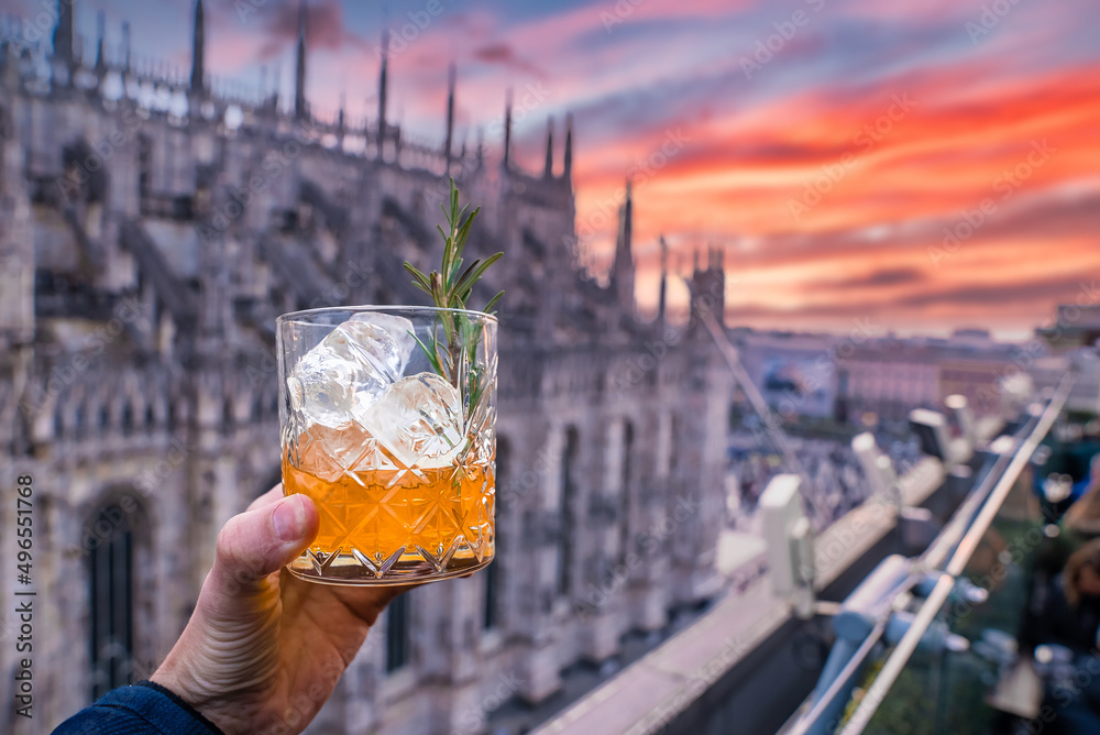 Naklejka premium Drinking delicious cocktail with an amazing view of the Milan Cathedral in Italy.