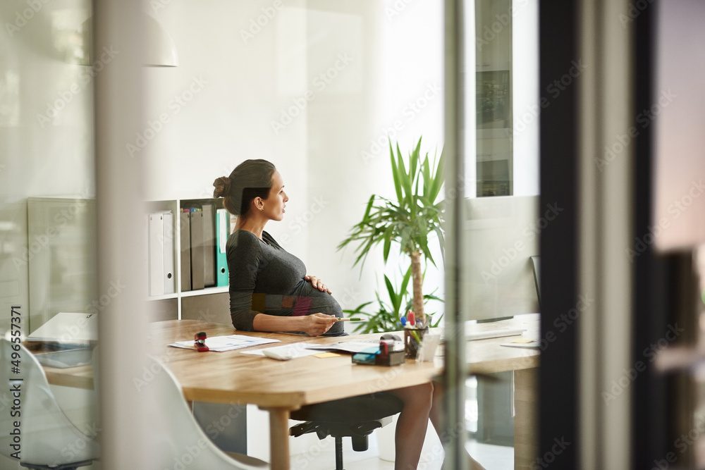 Reflecting on life and work. Shot of a pregnant businesswoman sitting in her office.