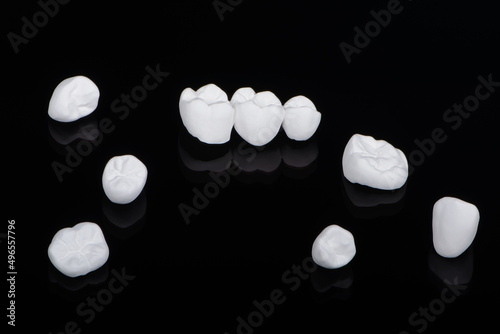 High aesthetic zirconia dentures and crowns on colorful background. Set of single dentures and dental crowns. photo