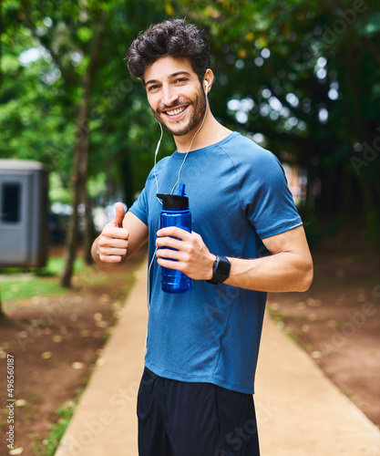 Youre well on your way to a better lifestyle. Portrait of a sporty young man holding a water bottle and showing thumbs up while exercising outdoors.