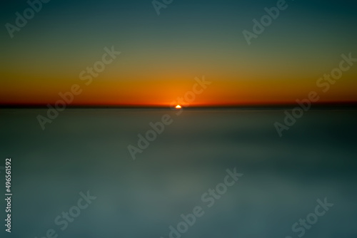 Large sunset copy-space abstraction using ICM featuring blue ocean and orange to red to blu sky