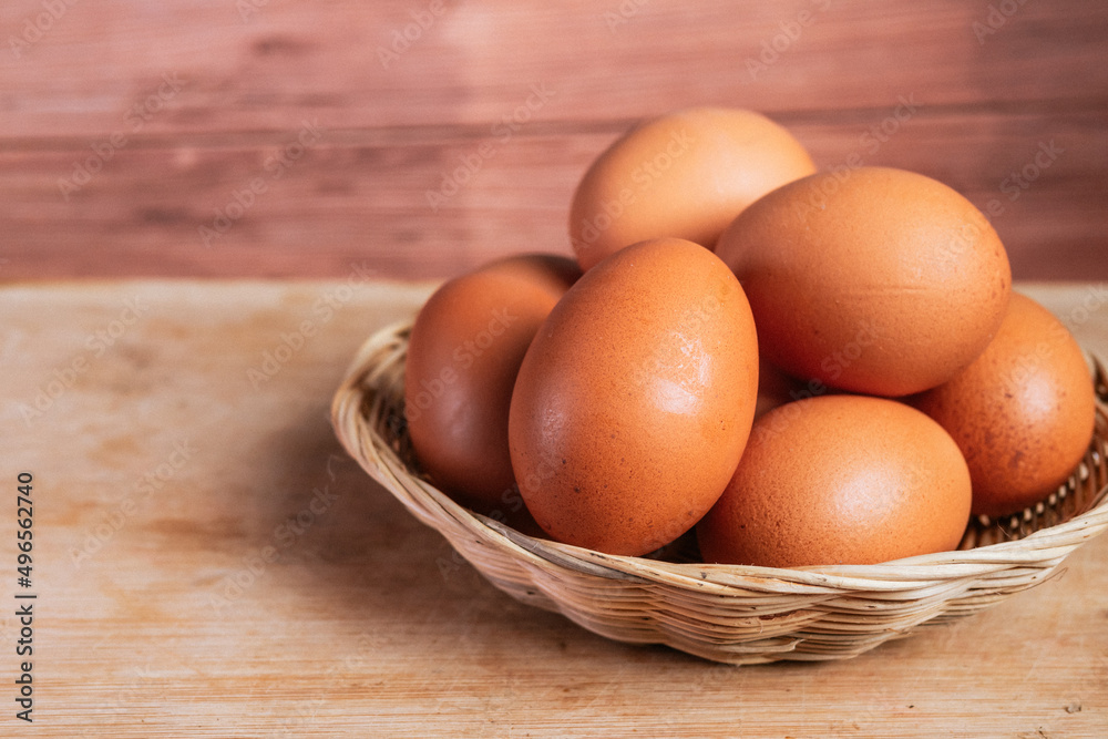 basket of fresh chicken eggs on a wooden table from agriculture farm. basket of fresh chicken eggs on a wooden table from agriculture farm.