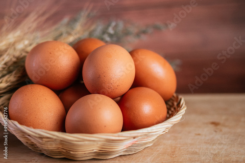 basket of fresh chicken eggs on a wooden table from agriculture farm.