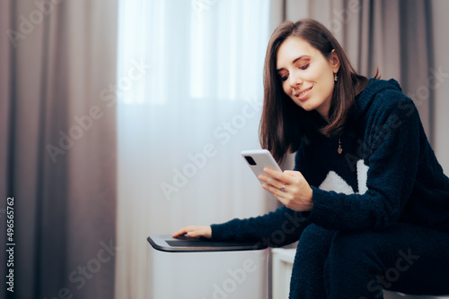 Woman Using Phone App to Control Humidity and Temperature in the Room 