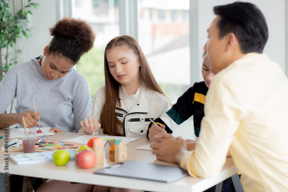 Group of student sitting and studying and learning drawing with teacher together in classroom at the school, pupils creativity and development for drawing in course, back to school, education concept.