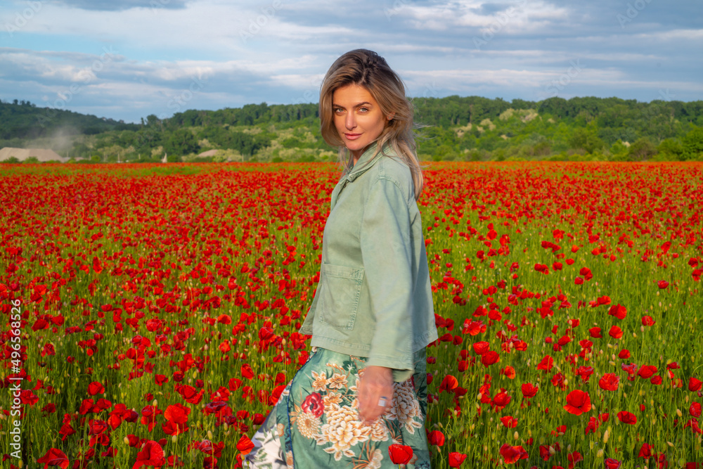 Happy woman resting on a beautiful poppy field. Girl having fun spring outdoor. Woman in field with red poppies. Happy woman resting on a beautiful poppy field. Girl having fun spring outdoor. Woman in field with red poppies.