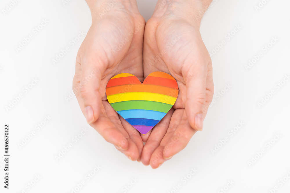 Female hands with rainbow paper heart isolated on white background. Female hands with rainbow paper heart isolated on white background.