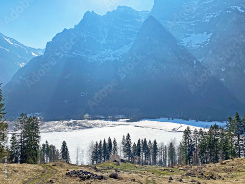 Frozen Klöntalersee or Klontaler Lake during early spring in the Alpine valley Klöntal (Kloental or Klontal) and in the Glarus Alps mountain massif - Canton of Glarus, Switzerland (Schweiz) photo