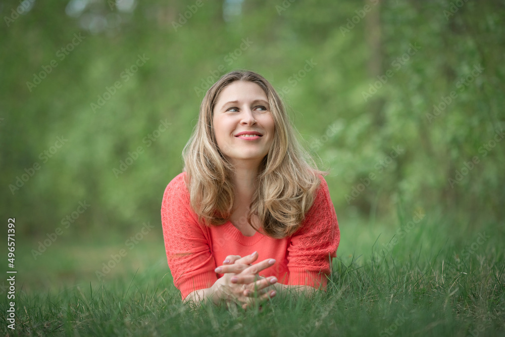Beautiful blonde young woman in a pink blouse in the park. Beautiful blonde young woman in a pink blouse in the park.