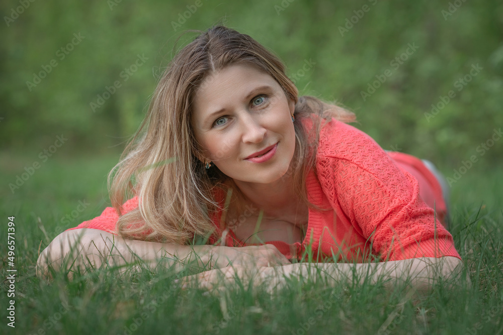 Beautiful blonde young woman in a pink blouse in the park. Beautiful blonde young woman in a pink blouse in the park.