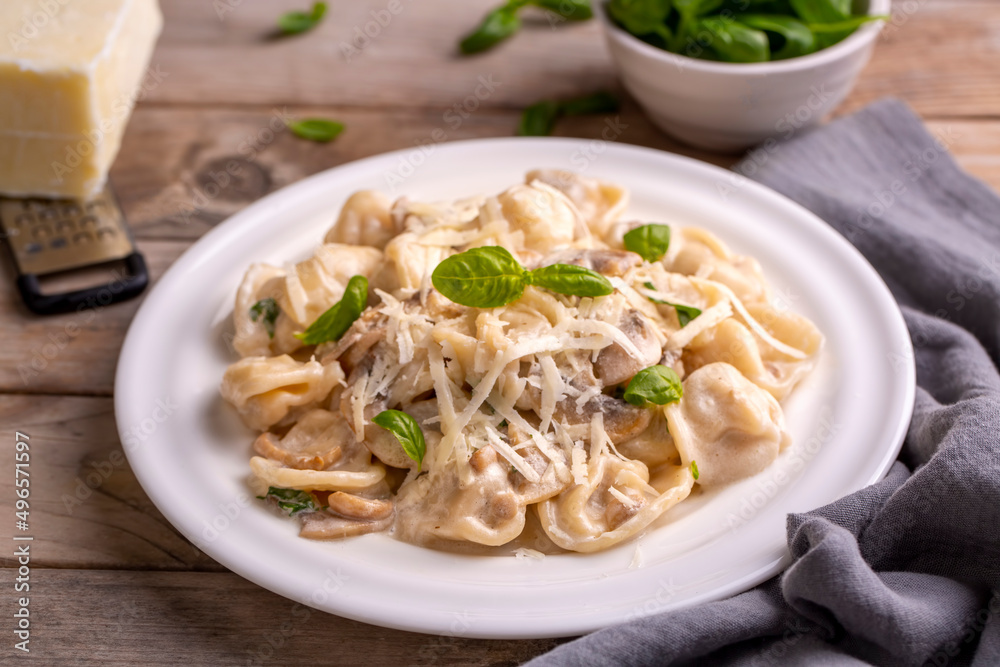 Tortellini with creamy mushroom sauce, grated cheese