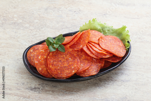 Sliced pepperoni sausage in the bowl photo