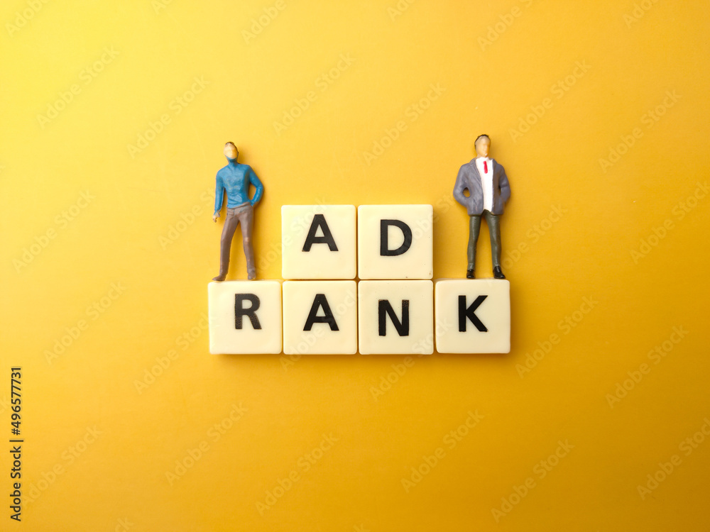 Miniature people and toys word with text AD RANK on yellow background.