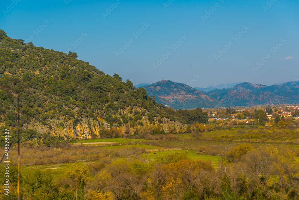 DALYAN, TURKEY: Landscape with a view of the road, mountains and the town of Dalyan on a sunny day.
