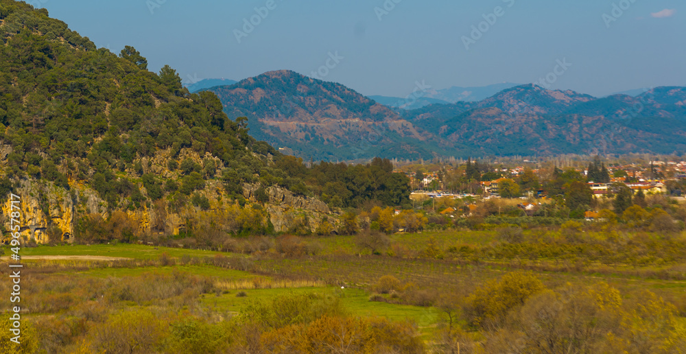 DALYAN, TURKEY: Landscape with a view of the road, mountains and the town of Dalyan on a sunny day.