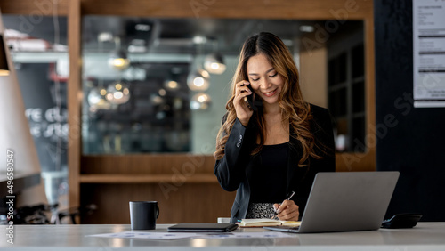 Εκτύπωση καμβά Asian woman talking on the phone, she is a salesperson in a startup company, she is calling customers to sell products and promotions