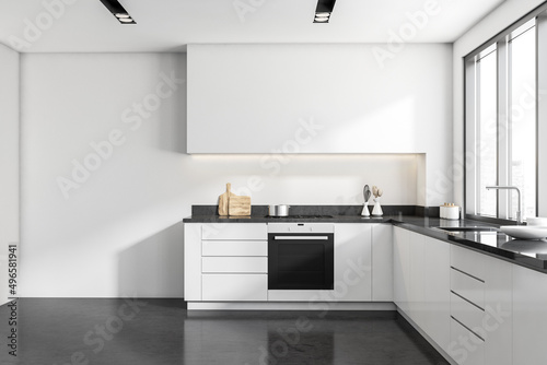 Front view on bright kitchen interior with empty white wall photo