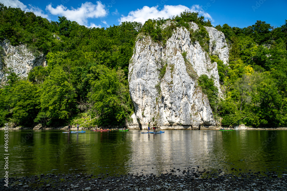 Rocks of the Danube Gorge with green forest, blue sky, water and beach of the Danube. Danube Gorge in Bavaria Germany. Rocks of the Danube Gorge with green forest, blue sky, water and beach of the Danube. Danube Gorge in Bavaria Germany.
