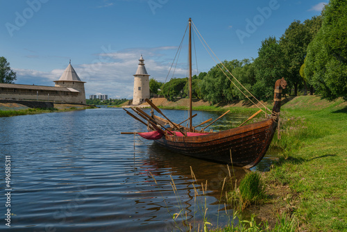 View of the Slavic and Old Russian sailing and rowing sea and river vessel rook against the background of the Pskov Kremlin (krom) on a sunny summer day, Pskov, Russia
