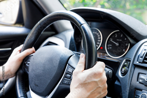 Male driver hand holding on steering wheel. Urban driving lifestyle