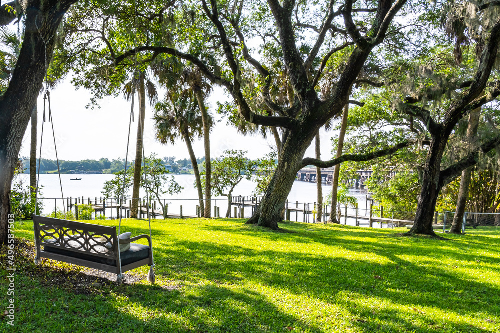 Rope swing tied to an old tree on a lawn by the Saint Sebastian River in the early morning. A typical view of the beautiful nature of Florida Rope swing tied to an old tree on a lawn by the Saint Sebastian River in the early morning. A typical view of the beautiful nature of Florida