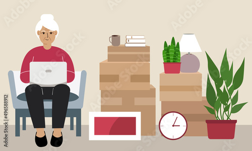 Grandmother at home with a laptop sits in a chair. The concept of online registration of delivery of boxes, goods and assistance in moving.