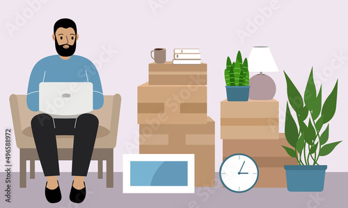 A man at home with a laptop sits in a chair. The concept of online registration of delivery of boxes, goods and assistance in moving.