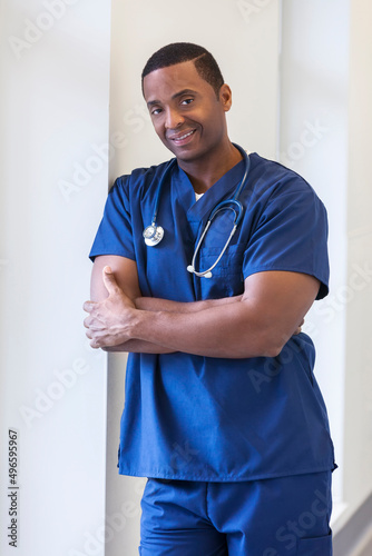 Smiling portrait of young African American male nurse wearing scrubs medical clinic