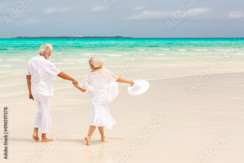 Fototapeta Naklejka Na Ścianę i Meble -  Senior Caucasian couple in casual white clothes on a tropical beach vacation