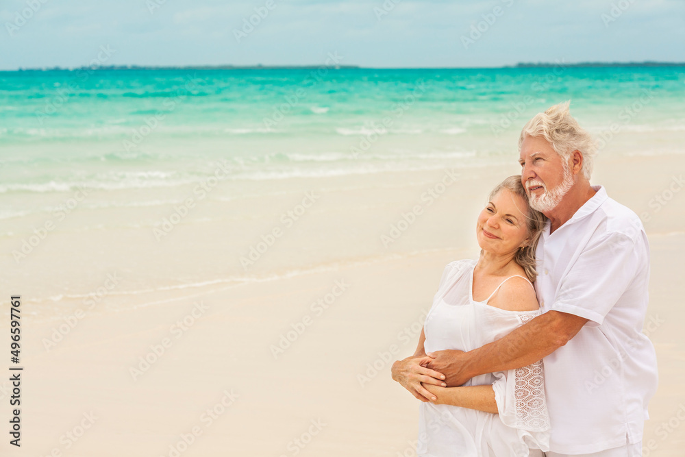 Caucasian senior couple in love wearing white clothes on a travel resort beach Caucasian senior couple in love wearing white clothes on a travel resort beach