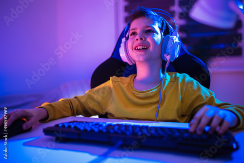 Little boy playing video game in the dark room © Mediteraneo