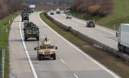 Army military convoy passes  in Czech Republic. Wheeled armored vehicles drive on highway . photo