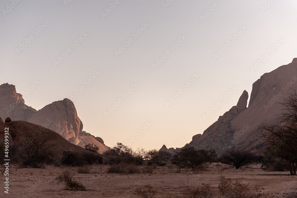 The setting sun is about to disappear behind Spitzkoppe, a famous mountain in central Namibia.