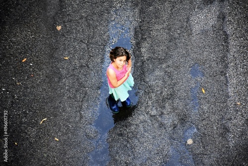 Bambina si diverte giocando sotto la pioggia estiva