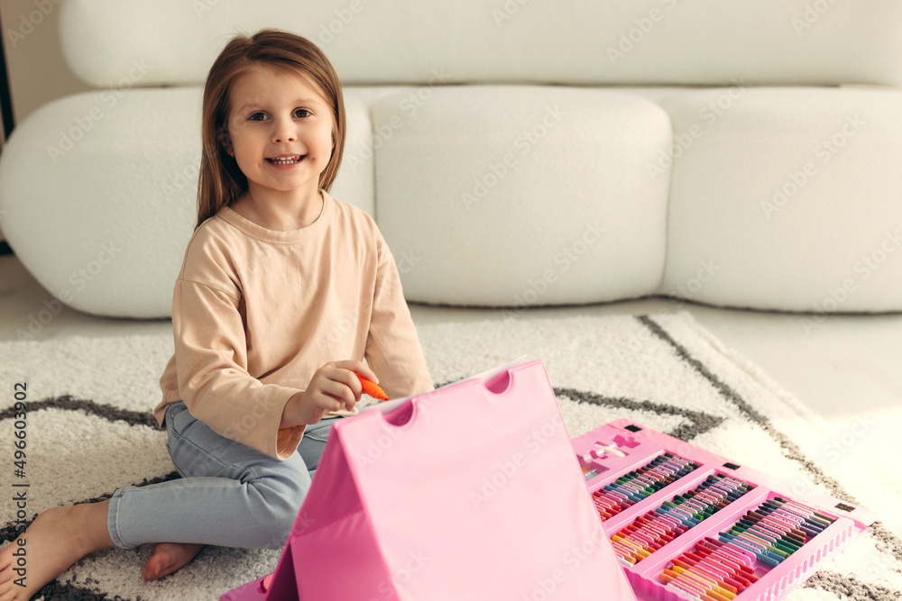 portrait of a little cute girl. girl paints at home on the floor portrait of a little cute girl. girl paints at home on the floor