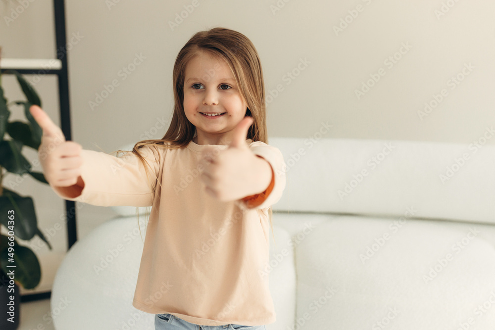 portrait of a cute smiling little girl at home. girl shows like portrait of a cute smiling little girl at home. girl shows like