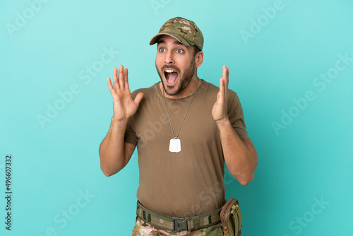 Military with dog tag over isolated on blue background with surprise facial expression