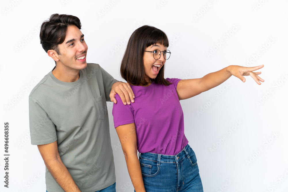Young couple isolated on isolated white background presenting an idea while looking smiling towards Young couple isolated on isolated white background presenting an idea while looking smiling towards