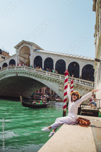 woman sitting near rialto bridge in venice italy looking at grand canal with gondolas © phpetrunina14