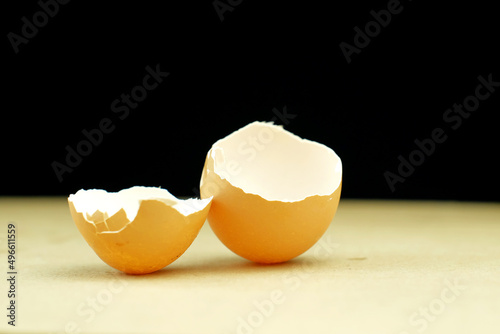 Eggshell broken into two pieces on table with black background