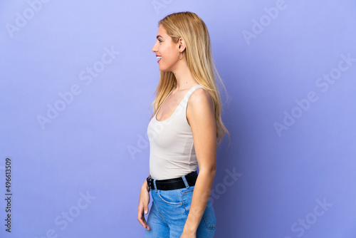 Young Uruguayan blonde woman over isolated background laughing in lateral position