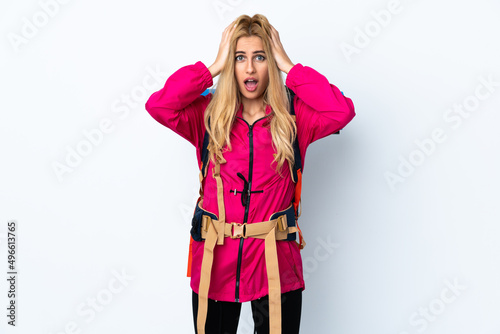 Young mountaineer woman with a big backpack over isolated white background with surprise facial expression