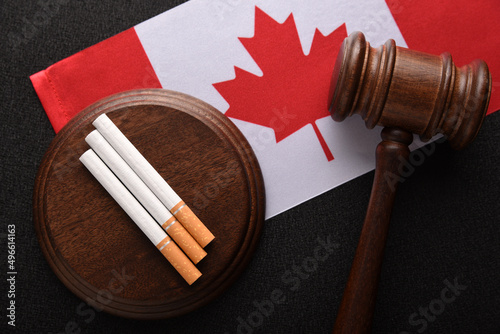 Flag of Canada, cigarettes and Judge gavel. Illegal sale of tobacco products. Tobacco law in Canada. photo