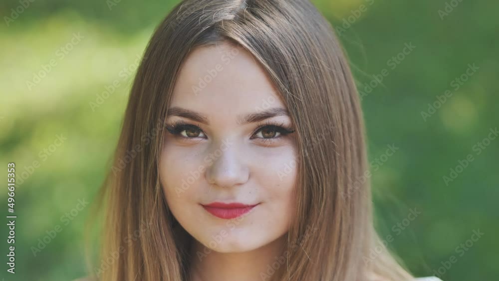 Portrait of a young girl in a park. Close-up of her face. Portrait of a young girl in a park. Close-up of her face.