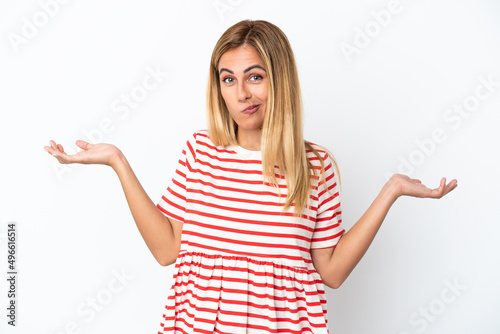 Blonde Uruguayan girl isolated on white background having doubts while raising hands