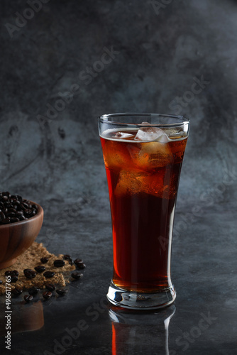 Iced Americano coffee in the glass with coffee beans in background. Diet drink or no sugar concept.