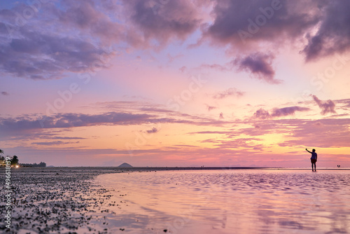Beautiful sunset on the sea shore with sky reflection in water. © luengo_ua